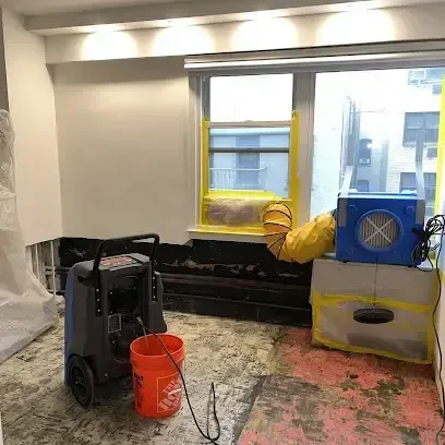 Pasadena structural drying: dehumidifier and air mover in a room with the flooring removed