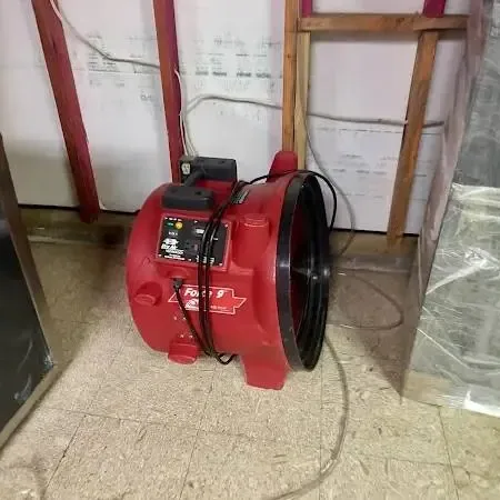 Air movers and a dehumidifier running in a drying room